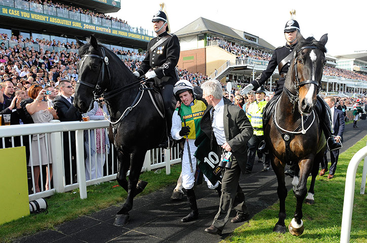 Grand National: Jason Maguire is escorted to the winners enclosure minus his mount