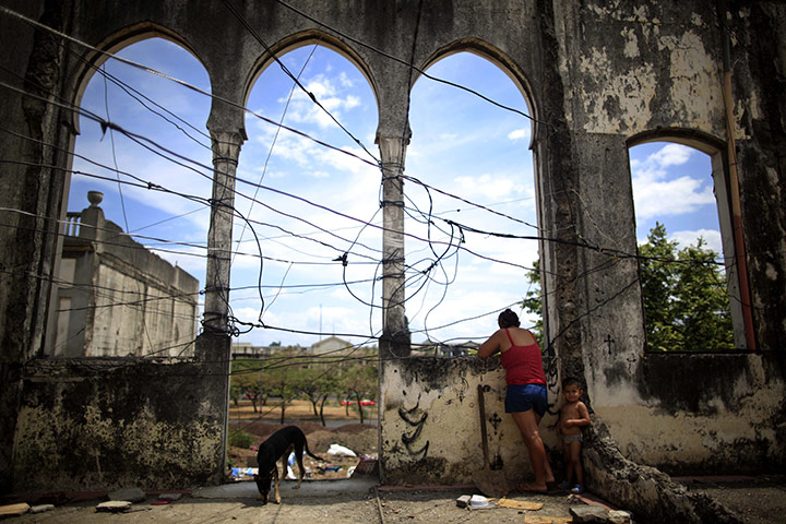 24 hours: Managua, Nicaragua: A woman and child stand in earthquake damaged building