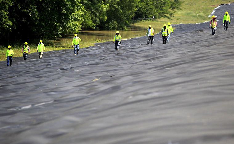 24 hours : Vicksburg, USA: Workers check a high density polyethylene barrier 