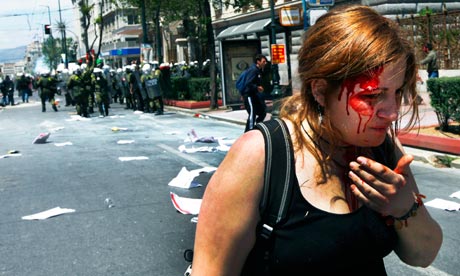 An injured protester bleeds following clashes with riot police in central Athens