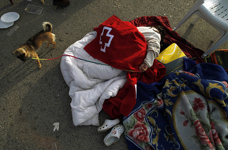 Lorca earthquake: A girl lies on the ground after spending the night in the open 