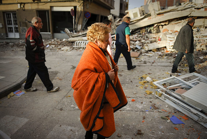 Lorca earthquake: People walk in front of a collapsed building in Lorca