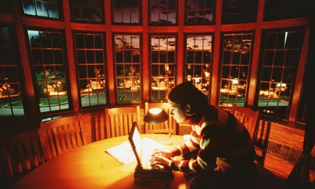 Young woman using laptop by lamp light