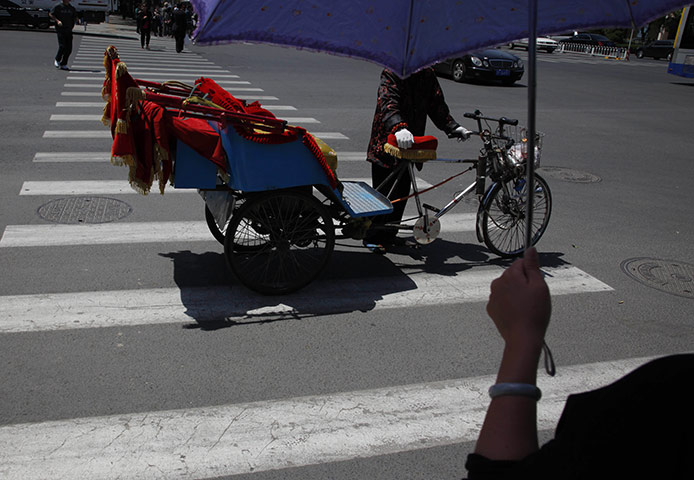 From the Agencies: A rickshaw man waits to cross the traffic lights
