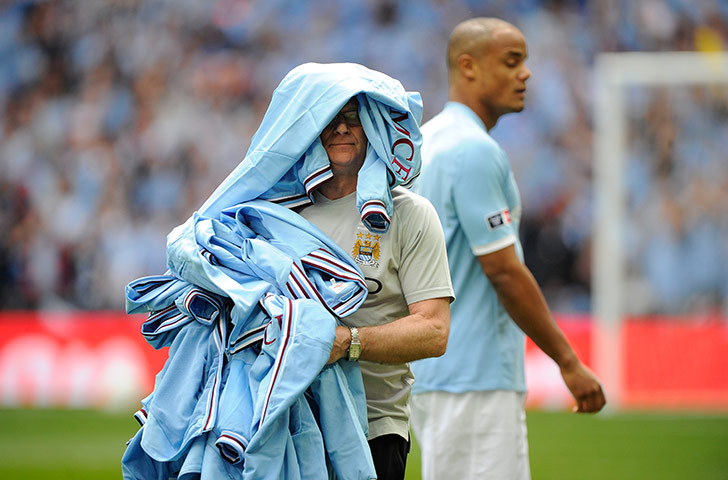 FA Cup Final City v Stoke: The City kit man takes the tracksuits just before kick-off