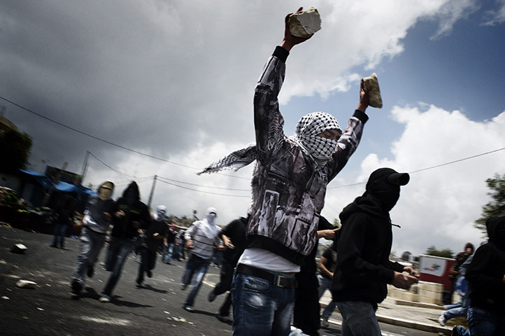 24 hours: Jerusalem: Palestinians prepare to throw stones during clashes at a funeral