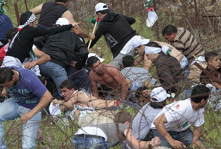 Israel violence: Palestinian protesters take cover after Israeli soldiers opened fire