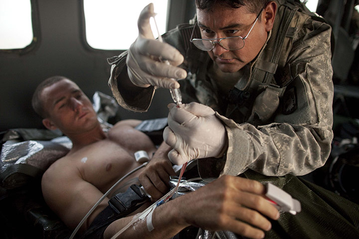 24 hours in pictures: A US army medic gives a pain killing injection to a wounded marine