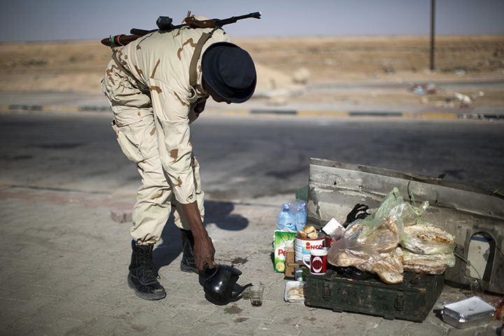 24 hours in pictures: Rebel fighter serves a cup of tea at a checkpoint, Libya
