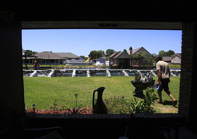 Mississippi floods: A man pushes a wheelbarrow filled with sandbags in Stephensville, Louisiana