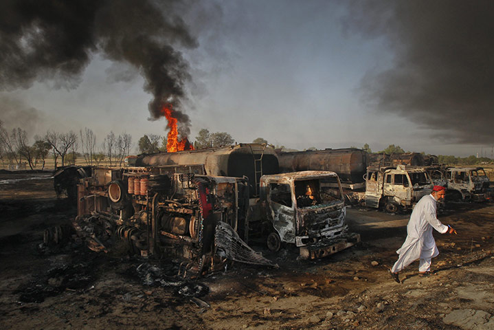 24 hours: Pindi Gheb, Pakistan: A resident walks past fuel tankers