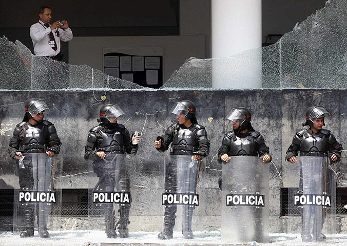24 hours: Cali, Colombia: Riot police stand guard outside a communications company