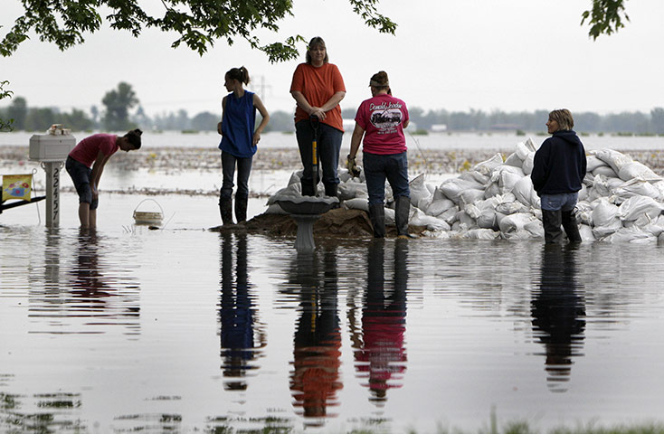24 hours: Illinois, USA: A woman stands on a pile of sandbags 