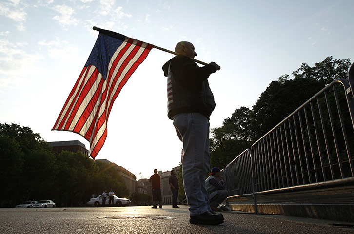 Bin Laden US reaction: A man holds a US flag outside the White House in Washington 