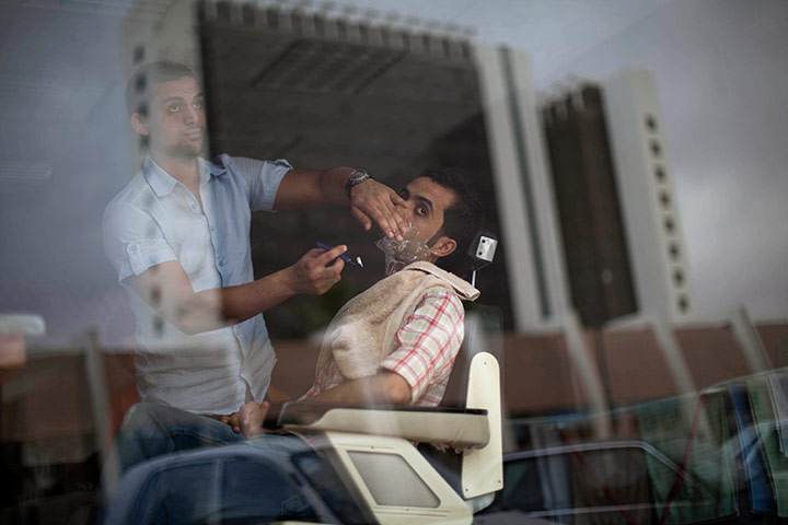 24 hours in pictures: Barber shaves a beard in Benghazi, Libya