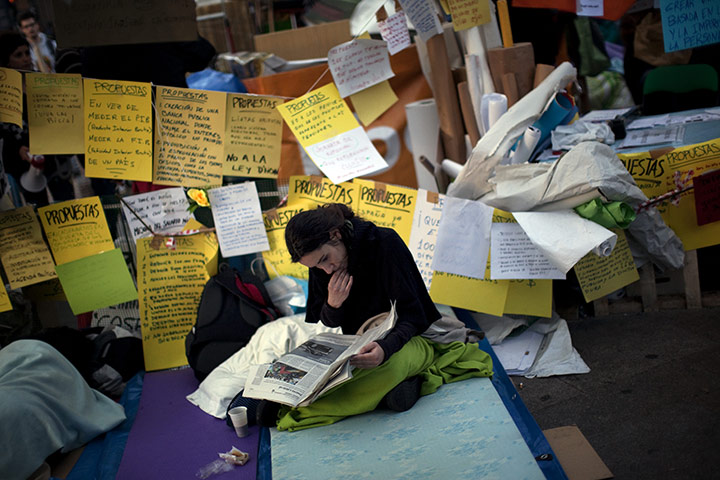 Spain protests: a demonstrator reads a newspaper