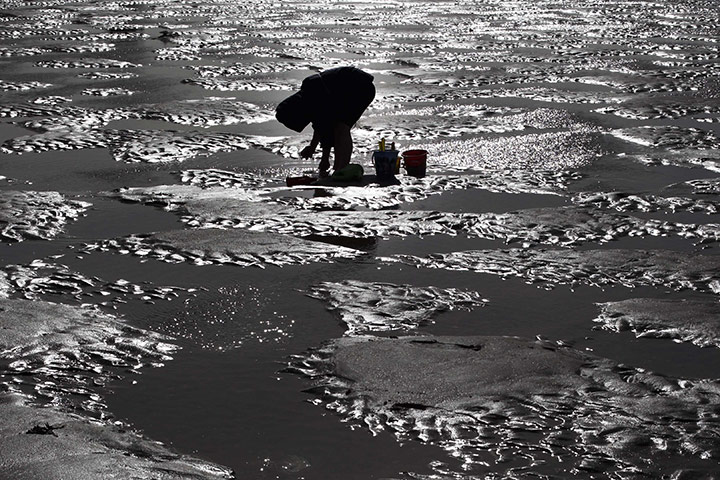 24 hours: Trouville, France: A young boy plays at sunset on the beach in the village 
