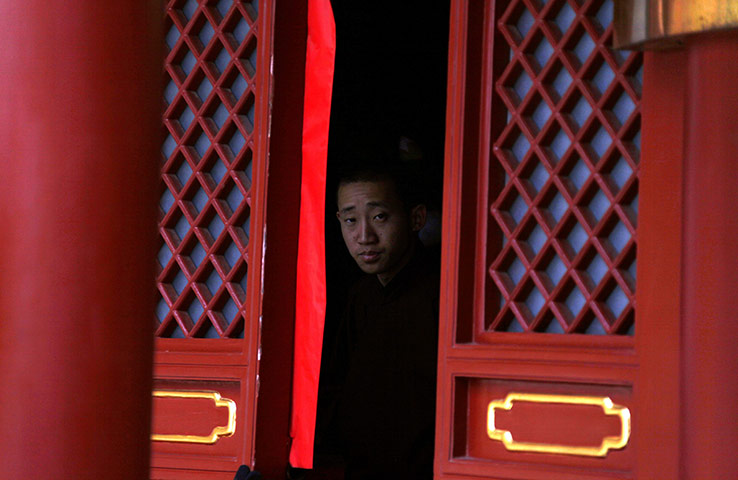 24 hours: Beijing, China: A Buddhist monk looks out the window
