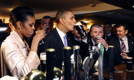 奥巴马和米歇尔在奥巴马抿吉尼斯酒吧，因为他们访问Moneygall，爱尔兰