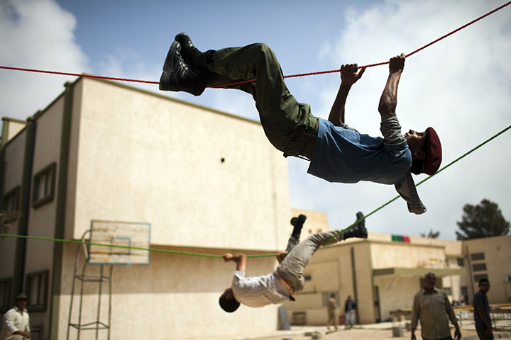 24 hours: Misrata, Libya: Young men hold ropes during a military training exercise 