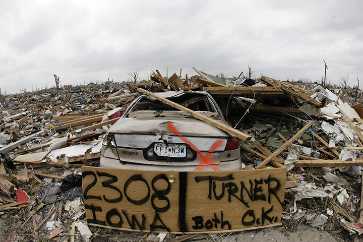 Tornadoes in US: A door with a home owner's address, rests against a destroyed car in Joplin