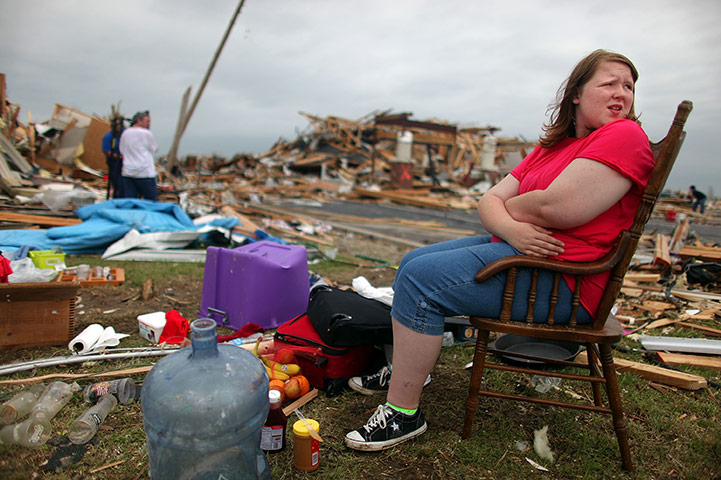 Tornadoes in US: A girl sits outside her family home which was destroyed in Joplin, Missouri