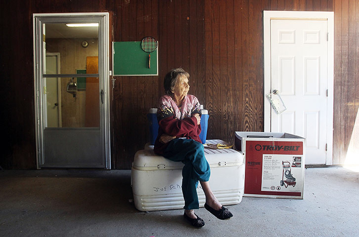 FTA Mario Tama: A woman looks on as family members pack the contents of her home