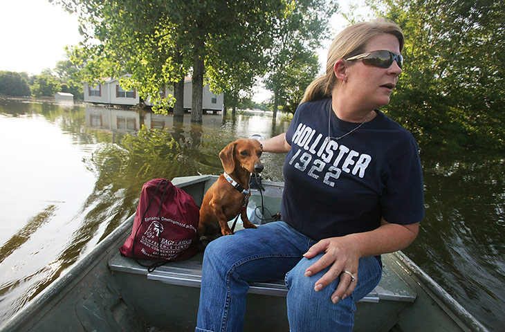FTA Mario Tama: A woman rides with her dog Bo near her home on the Mississippi River 