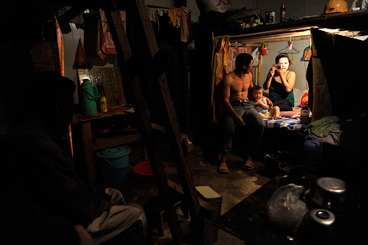 24 hours in pictures: A migrant worker sits bed as his wife uses a facial mask, China