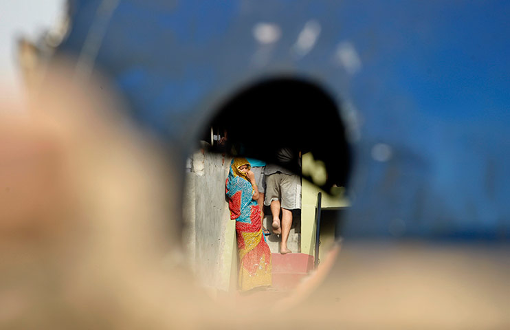 24 hours in pictures: Resident seen through the window of a small plane that crashed, India