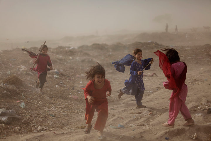 24 hours in pictures: Pakistani girls react as they get caught in a sand storm