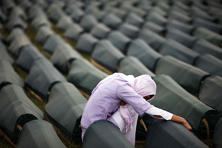 Ratko Mladic: A Muslim woman prays beside the coffin of her relative, a Srebrenica victim