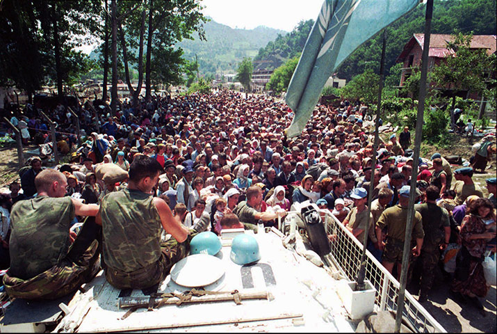 Ratko Mladic: Dutch UN peacekeepers sit while Muslim refugees from Srebrenica gather