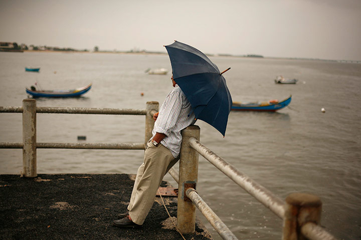 24 hours in pictures: A man leans on a rail at the port in Alcochete, Portgual