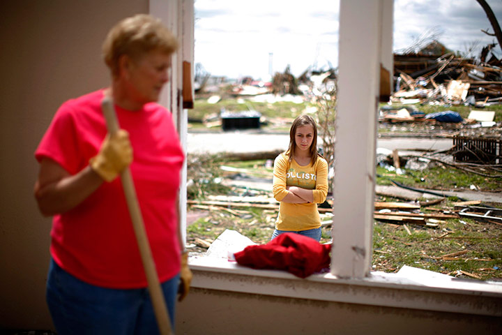 24 hours in pictures: Woman works removing debris in the destroyed home after a tornado in Joplin