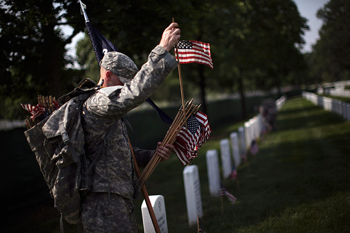 24 hours in pictures: Soldier places American flags at the graves at Arlington National Cemetery