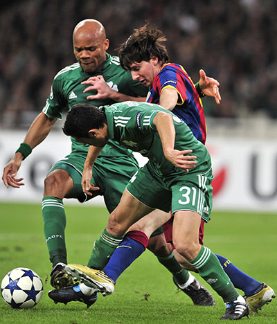 Barcelona3: Barcelona's Lionel Messi (C) fights for