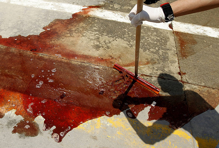 Middle East Unrest: A worker washes away blood at Misrata's hospital