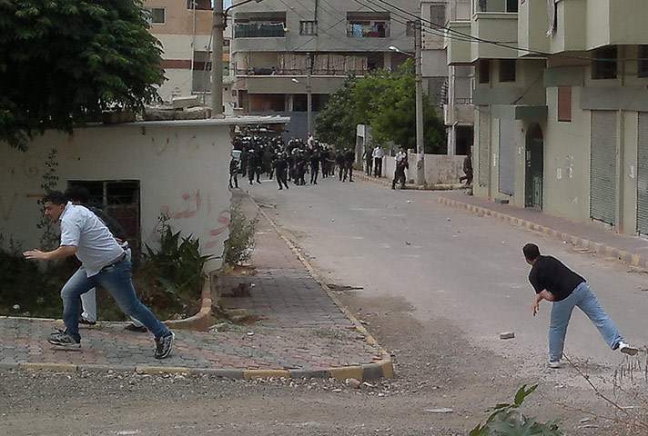 Middle East Unrest: Men throw stones at riot police