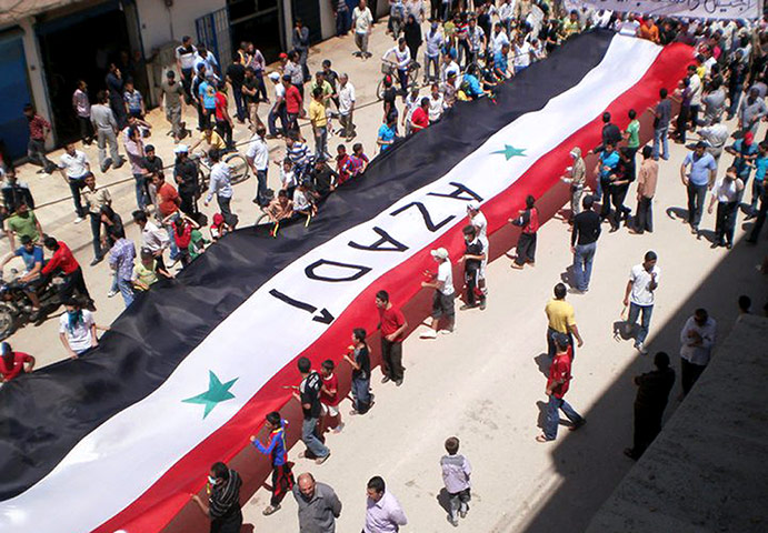 Middle East Unrest: Syrian Kurds hold a huge Syrian flag