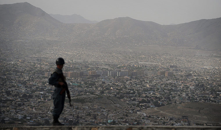 24 Hours: An Afghan policeman keeps watch over the city of Kabul