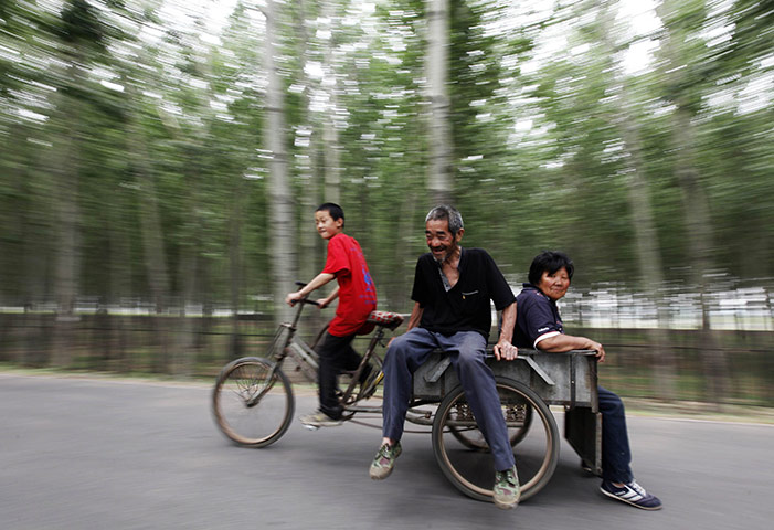 24 hours: Beijing, China: A boy rides a cart carrying his grandparents