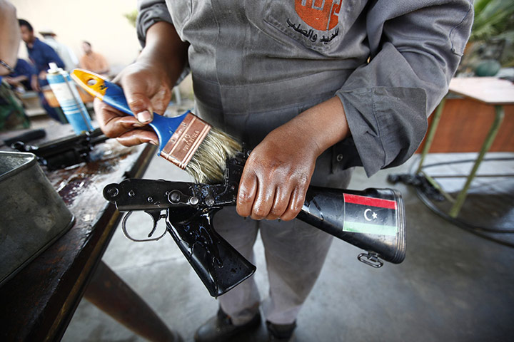 24 hours: Misrata, Libya: A Libyan volunteer removes rust from a gun