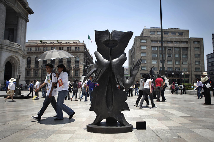 24 hours: Mexico City, Mexico: People walk past a sculpture by Leonora Carrington