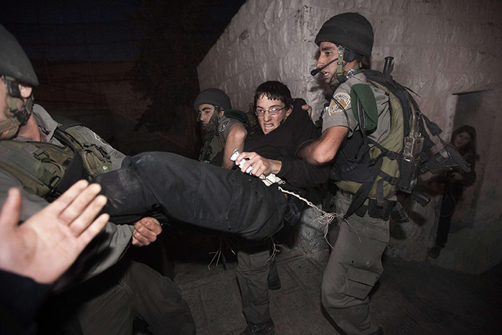 24 hours in pictures: An ultra-nationalist Israeli settler is arrested by Israeli policemen