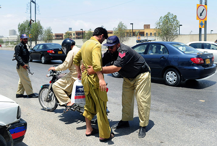 Pakistan : A policeman searches a man on a road linked to the US consulate in Karachi