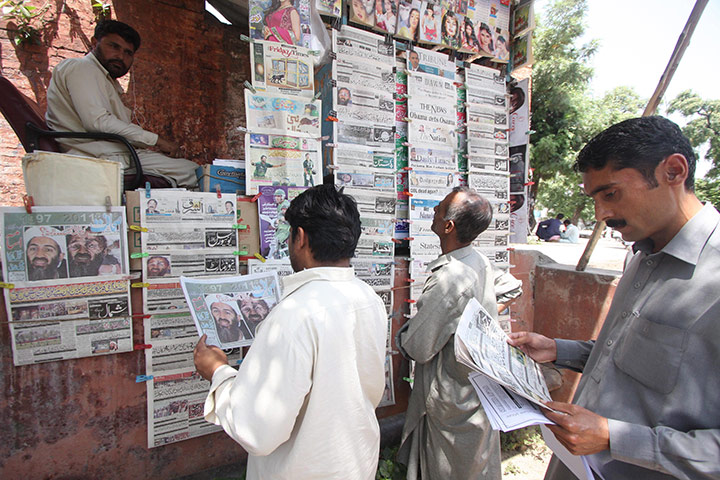 Pakistan : Men read newspapers on the death of Osama Bin Laden, in Islamabad