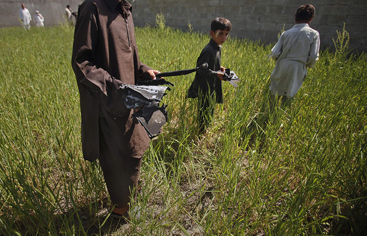 Pakistan : Boys collects debris, remains of a firefight, outside the compound 