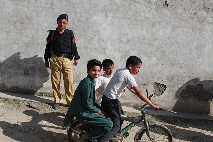 Pakistan : Local children pass the compound