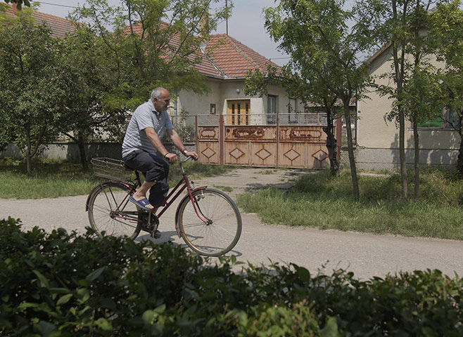 Ratko Mladic: 28 May 2011: A man rides a bicycle past the house where Mladic was found